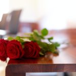 red roses on bench at funeral in church