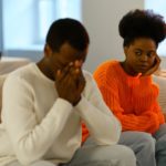 Les malentendus dans les relations amoureuses. Triste couple familial africain assis sur un canapé après un conflit