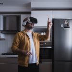 The young man who entered the world of the metaverse from the kitchen. touching with vr glasses.
