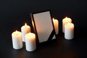 black ribbon on photo frame and candles at funeral
