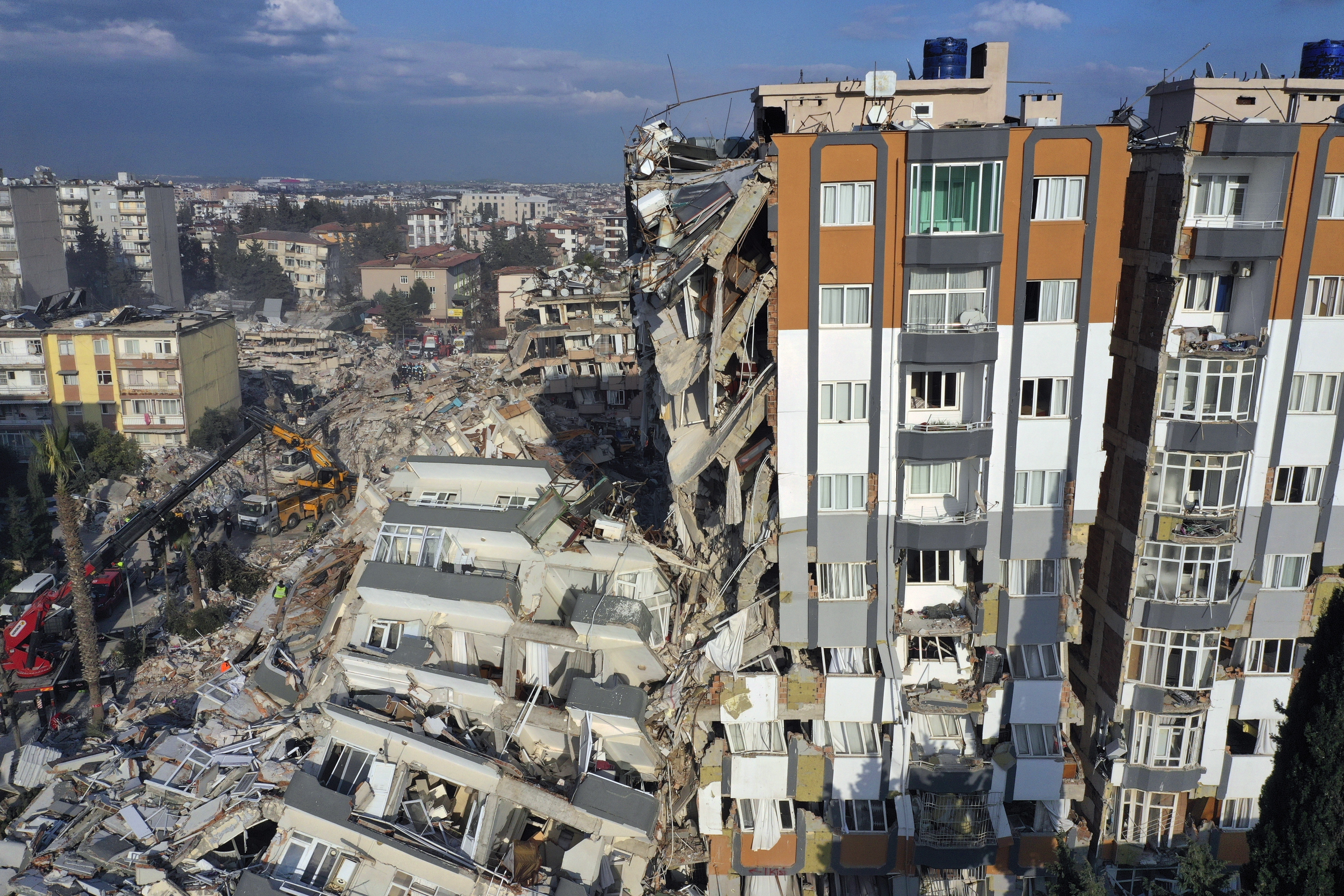 Cranes remove debris next to destroyed buildings in Antakya, southeastern Turkey.