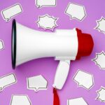 Electronic megaphone and speech bubble on purple background