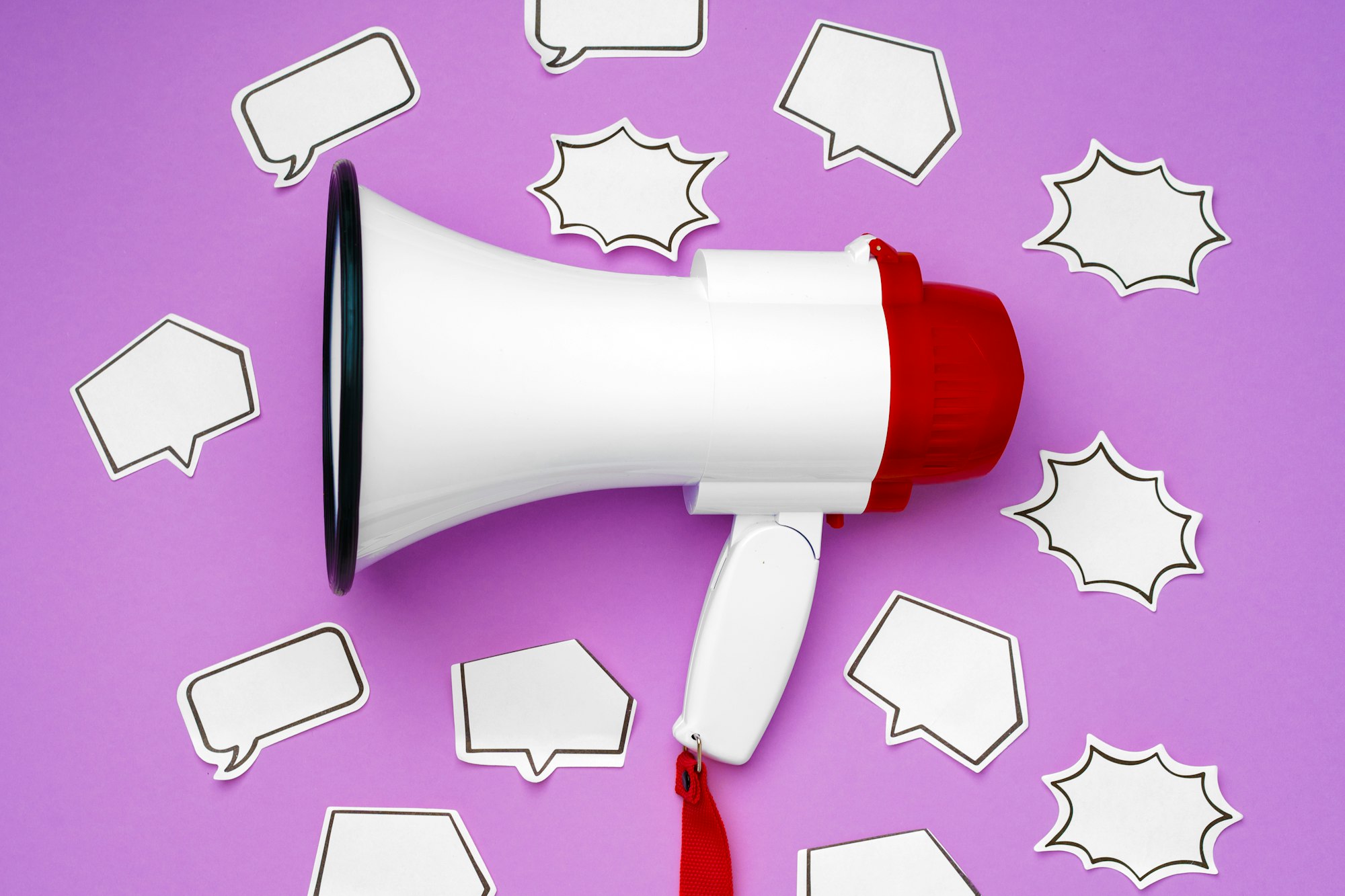 Electronic megaphone and speech bubble on purple background
