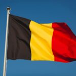Flag of Belgium on mast. National flag against wind blue sky