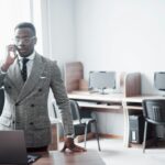 heerful african businessman standing in front of colleague
