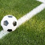 Traditional soccer ball on soccer field. black and White Soccer ball on green meadow