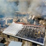 Ruined building on fire as example of rocket air strike result between Israel and Gaza