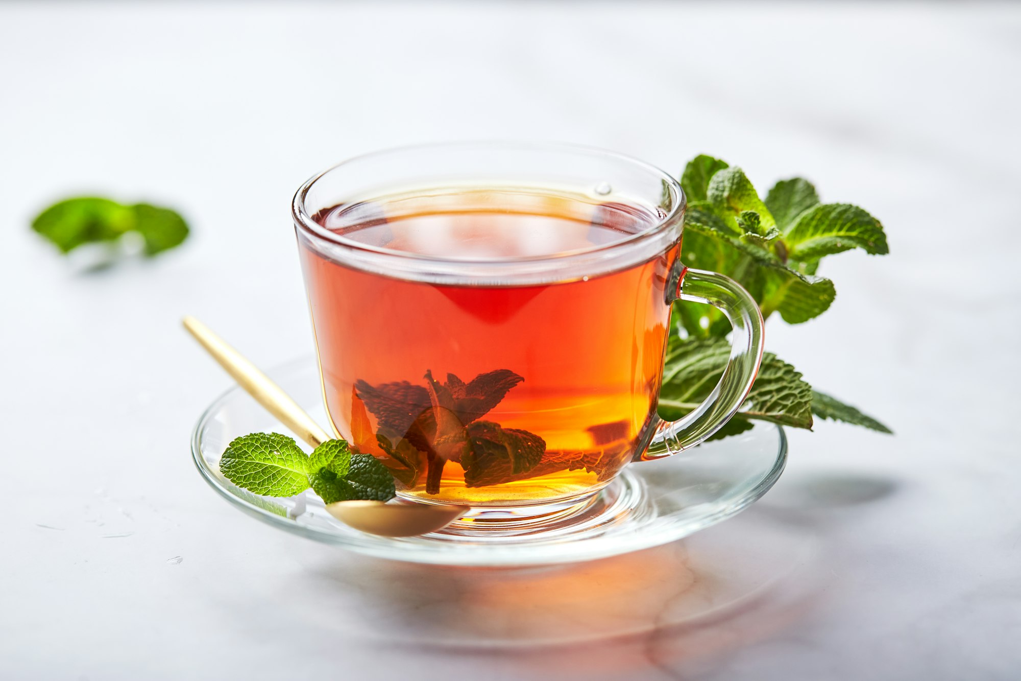 Aliments Anti-Stress: Black tea in glass transparent mug with mint leaves. Soothing tea, anti-stress