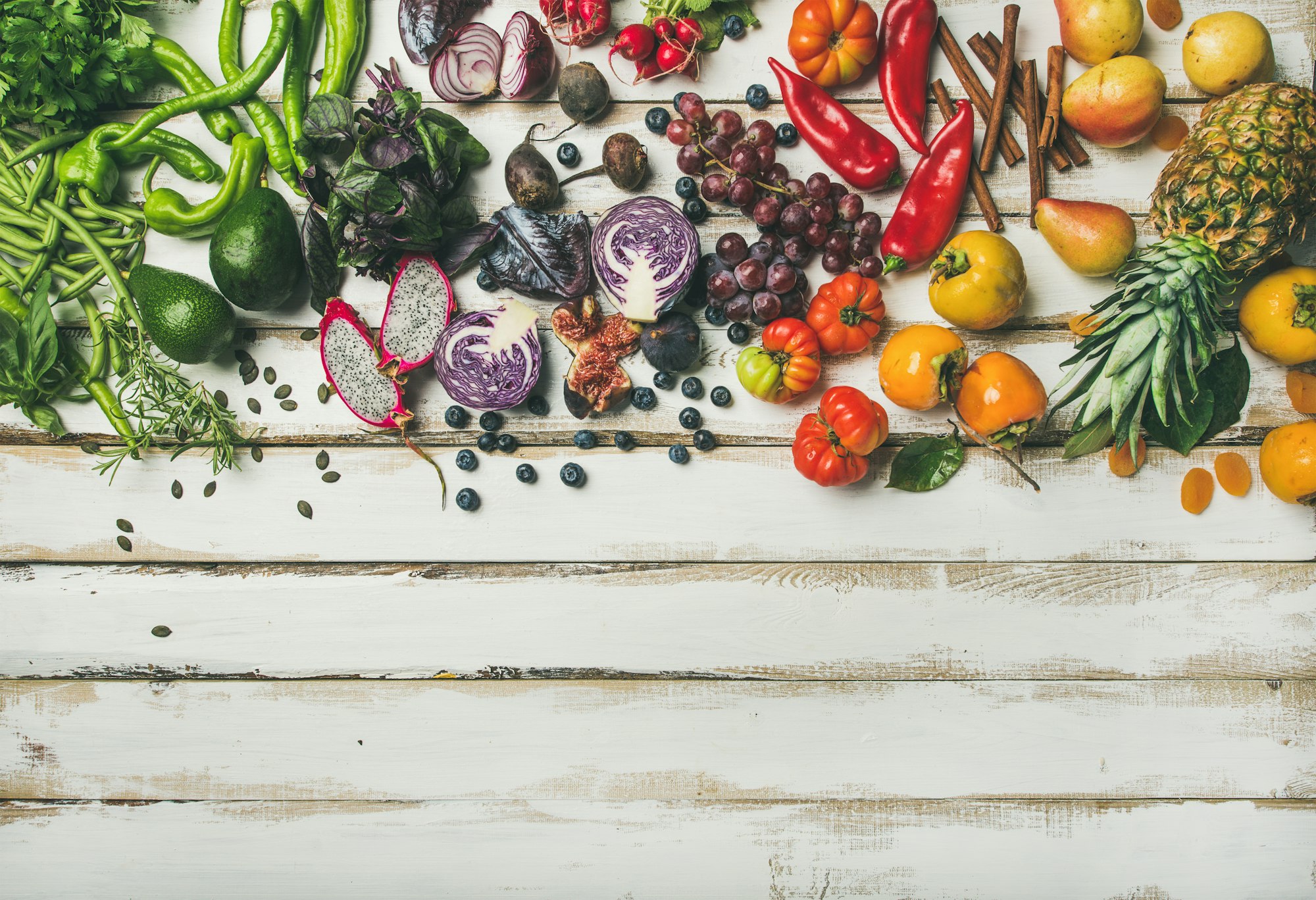 Superaliments: Flat-lay of fresh fruit, vegetables, greens and superfoods, copy space