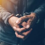 Arrested computer hacker with handcuffs