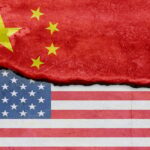 Flag of USA and China on cracked concrete wall background