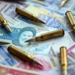 Many bullets and iranian rials money bills close up