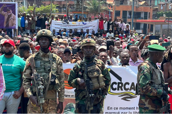 Des hommes en tenue militaire au premier plan d’un rassemblement public. Photo fournie à la rédaction, lieu et date non précisés.