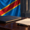 Illustration générée par IA d’un dossier administratif et d’un stylo sur un bureau, devant le drapeau de la RDC.