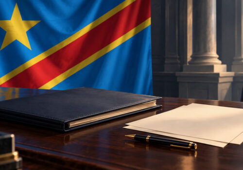 Illustration générée par IA d’un dossier administratif et d’un stylo sur un bureau, devant le drapeau de la RDC.